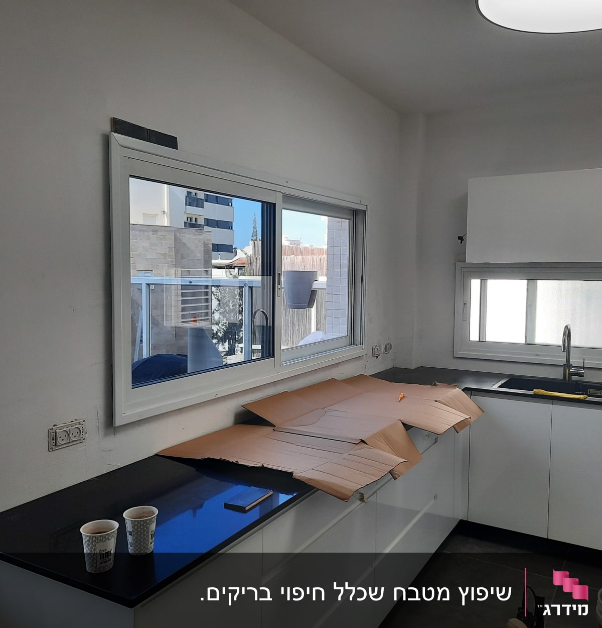 מטבח בשיפוץ עם קרטון על השיש וכלי עבודה